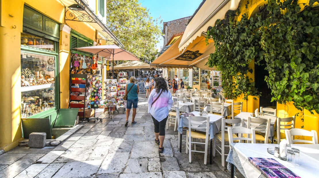 Tourists-walk-past-cafes-and-shops-through-narrow-streets-and-alleys-in-the-touristic-Plaka-district-in-the-heart-of-historical-Athens-1200x853